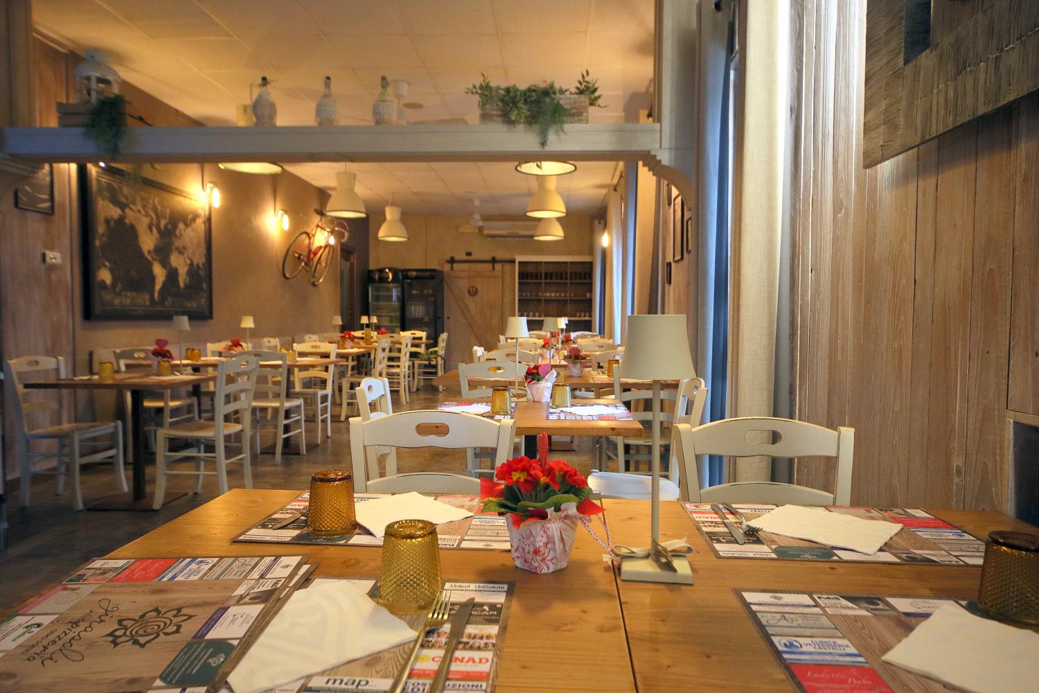 L’atmosfera del ristorante I Girasoli, con tavoli in legno e luci calde